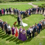 810_0614 Married couple standing with the dog in the middle of the heart made from the wedding guests.