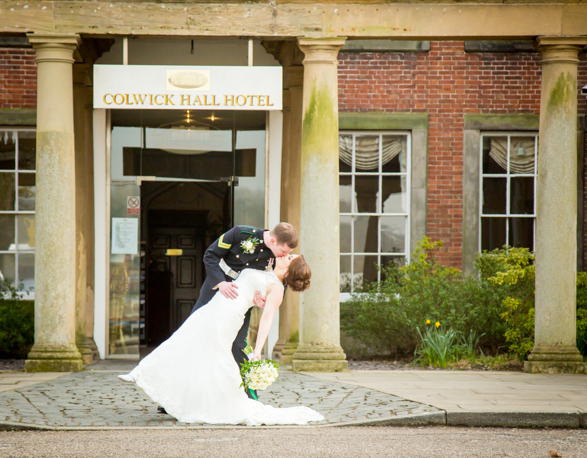 Newly weds kissing outside of Colwick Hall Hotel