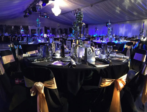 Image of event table with glasses, cutlery and programmes laid out on.